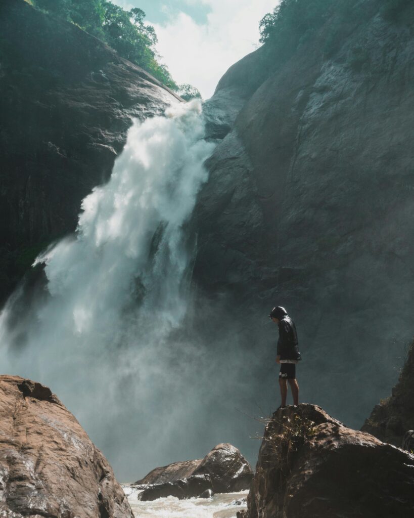 pexels-photo-1047051-1047051 A man standing near a breathtaking waterfall in Badulla, Sri Lanka, showcasing nature's beauty and adventure.