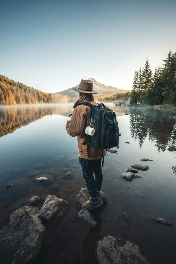 pexels-photo-3217911-3217911 A hiker with a backpack stands by a tranquil mountain lake, capturing the essence of adventure and serenity.